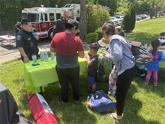 A family stops at the Carrboro Police table at Carrboro In Motion