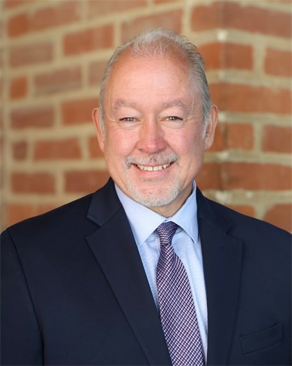 portrait of John Fussa in front of a brick wall