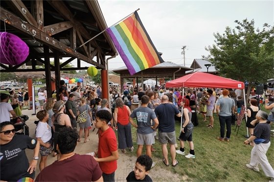 Carrboro Community gathers for Pride 2023 at the Town Commons. There are pride flags and people laughing, smiling and dancing