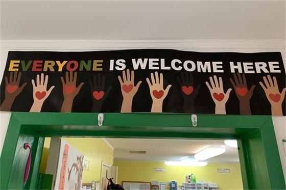 Banner with hands and hearts below the words "Everyone is welcome here"