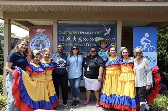 Carrboro In Motion pose in front of the sign at Collins Crossing