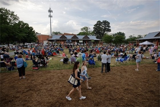A crowd is enjoying music at Carrboro Town Commons at a Freight Train Blues Concert
