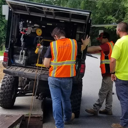 Vision NC standign at a work truck performing condition assessment work on Carrboro underground stormwater infrastructure
