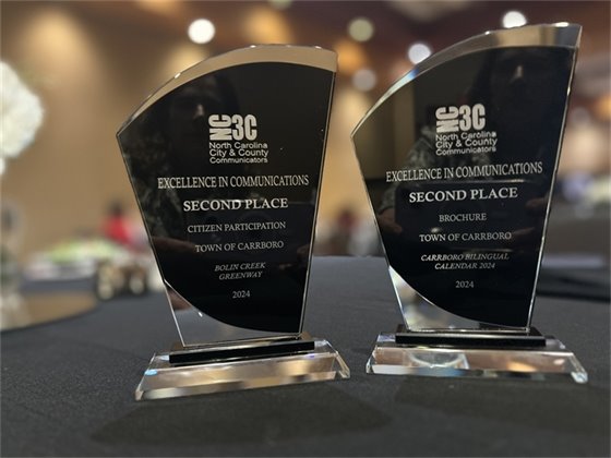 Two NC3C Excellence in Communications Awards on a table at the 2024 NC3C Conference