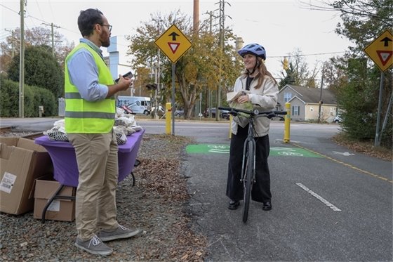 Planning staff handing out reflective gear to a biker